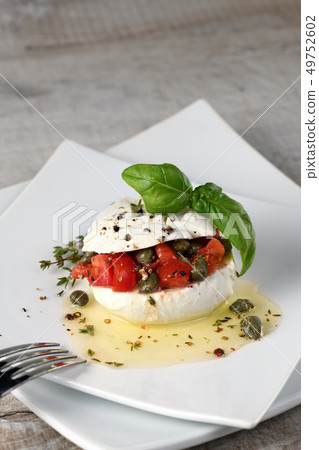 Mozzarella stuffed tomatoes with capers 49752602