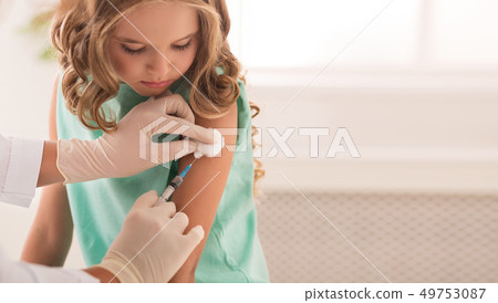 Doctor vaccinating little girl in hospital, copy space 49753087