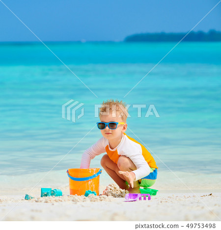 Three year old toddler playing on beach 49753498