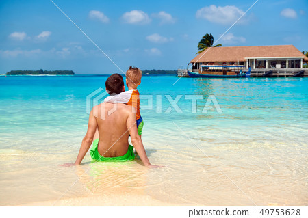 Toddler boy on beach with father Toddler boy on beach with father 49753628