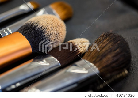Set of makeup brushes lying on darn surface close 49754026