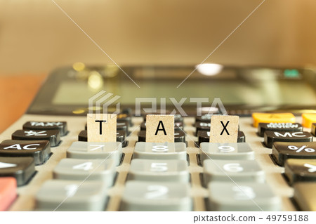 Calculator with the word tax written in paper conceptual. 49759188