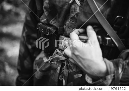Re-enactor Dressed As World War II German Wehrmacht Soldier Holds His Hands On A Cartridge Belt 49761522