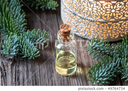 A bottle of fir essential oil with fresh fir 49764734