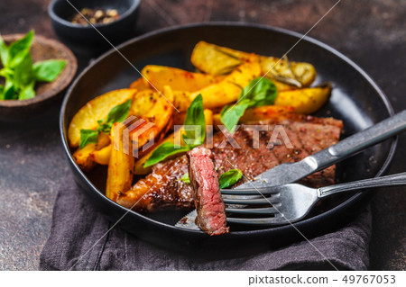 Grilled beef steak with potatoes and basil 49767053