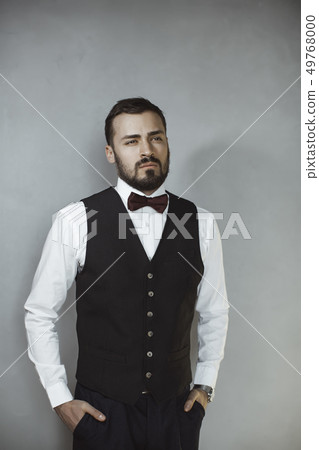 Smiling man in black vest and bow tie Smiling man in black vest and bow tie 49768000