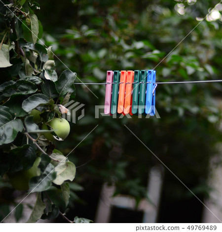 Clothespins on a rope hanging outside house and 49769489