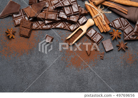 Dark or milk organic chocolate pieces and cocoa powder on dark concrete backgound 49769656