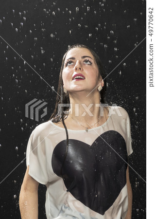 woman looking up at the rain woman looking up at the rain 49770642