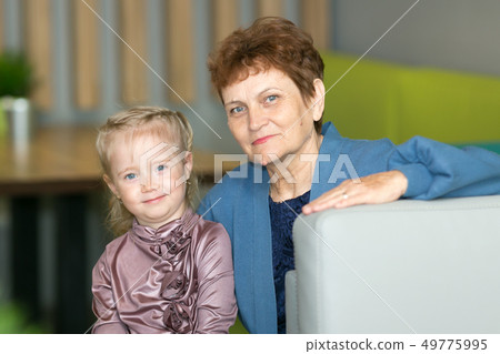 Little granddaughter tightly hugs her grandmother. Little granddaughter tightly hugs her grandmother. 49775995