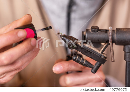 Close up of fisherman tying a fly for fishing. 49776075