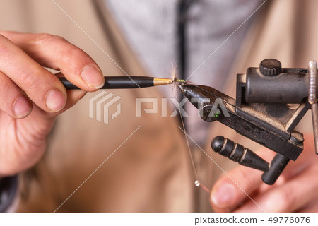 Close up of fisherman tying a fly for fishing. 49776076