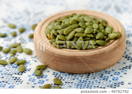 Peeled pumpkin seeds in wood bowl 49782792