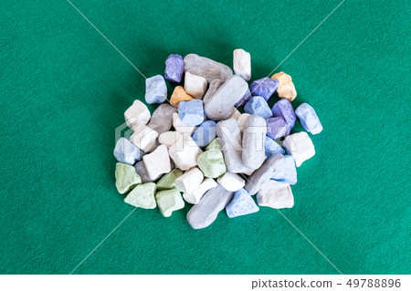 pile of various multicolored stones on green table pile of various multicolored stones on green table 49788896