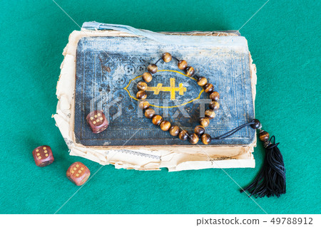 old book, worry beads and dices with six points 49788912