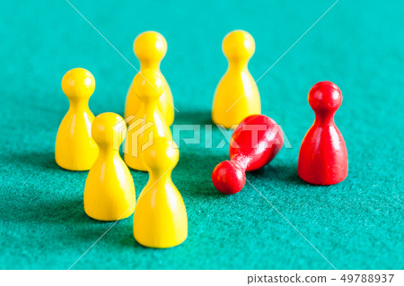 standing and fallen red pawn near yellow pawns standing and fallen red pawn near yellow pawns 49788937