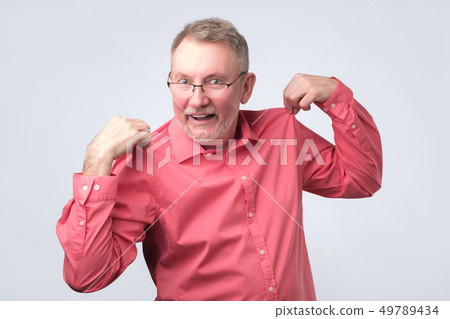 Good looking senior man adjusting shirt and smiling. Good looking senior man adjusting shirt and smiling. 49789434
