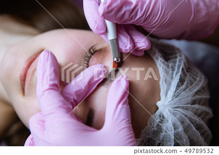 Permanent Makeup For Eyebrows. Microblading brow. Beautician Doing Eyebrow Tattooing For Female Face 49789532