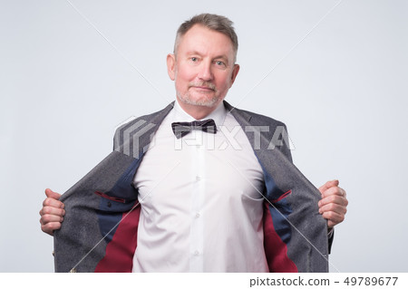 Senior man in suit and glasses looking at camera and laughing on funny joke. 49789677