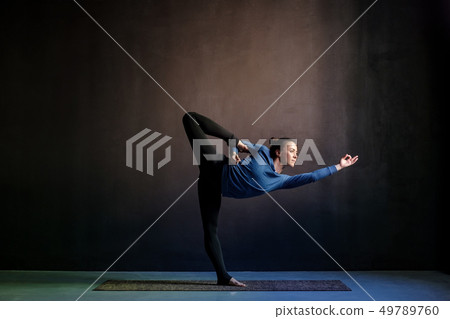 Woman practicing yoga, stretching in Natarajasana exercise 49789760