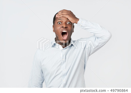 Shocked black male says wow, looks bugged eyes and rounded mouth, being amazed 49790864