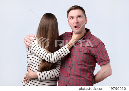 Angry woman try to strangle husband, studio shot Angry woman try to strangle husband, studio shot 49790910