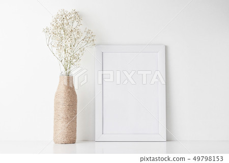 Workspace desk with empty frame and flower in vase 49798153