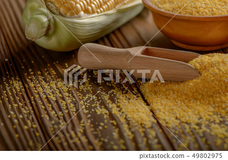 Bowl of corn grits and corncob on kitchen table Bowl of corn grits and corncob on kitchen table 49802975