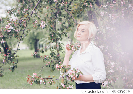 portrait of a beautiful blonde with short hair among flowers portrait of a beautiful blonde with short hair among flowers 49805009