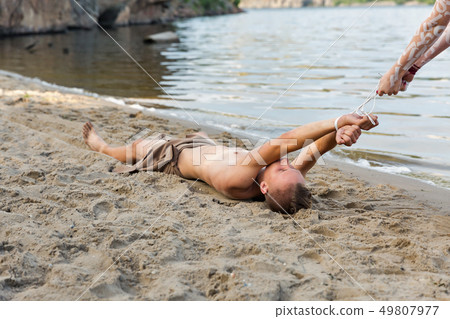 young white man in loincloth is bound by the river young white man in loincloth is bound by the river 49807977