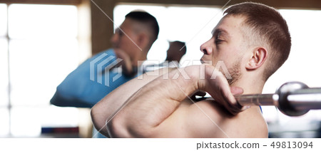 Young People in Gym Training With Barbells 49813094