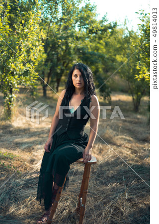 Girl sitting on a bar chair outdoors Girl sitting on a bar chair outdoors 49814013