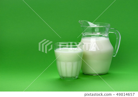 Jar and glass of milk isolated on green background with copy space for text, dairy product concept 49814657
