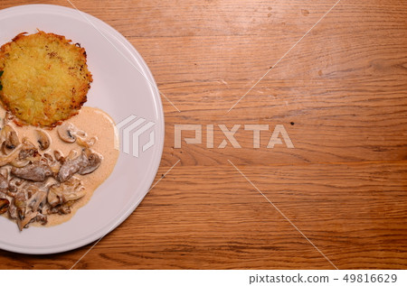 potato pie served with pork stew with mushrooms 49816629