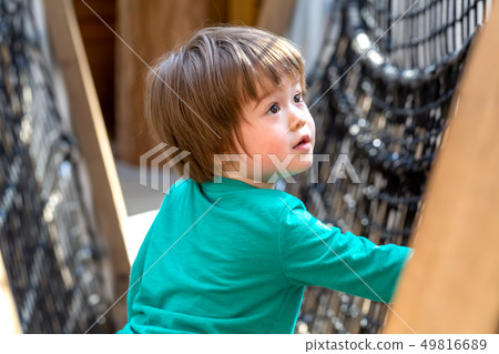 Toddler boy playing at a playground 49816689