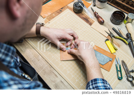 Concept of handmade craft production of leather goods. Concept of handmade craft production of leather goods. 49816819