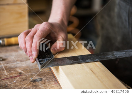 The worker makes measurements of a wooden board 49817406