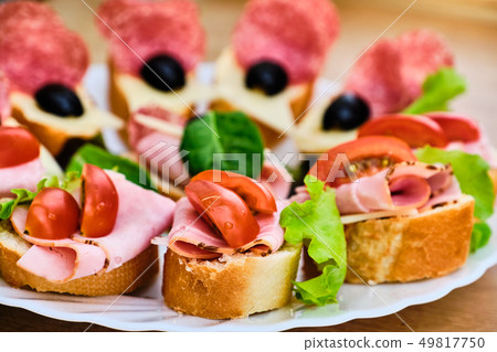 Small sandwiches with ham and salami Small sandwiches with ham and salami 49817750