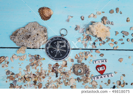 Time to Travel. Idea for tourism with compass on the sand with corals on the wooden background. Time to Travel. Idea for tourism with compass on the sand with corals on the wooden background. 49818075