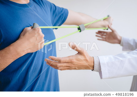 Doctor physiotherapist assisting a male patient Doctor physiotherapist assisting a male patient 49818196