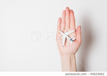 Airliner on the female palm on a light background. 49820862