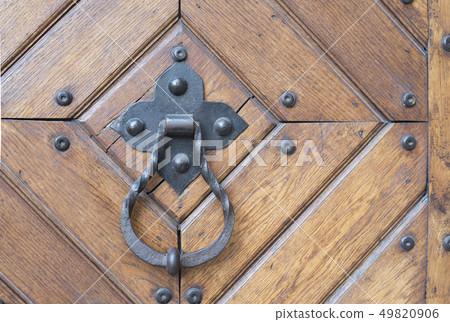 Forged metal door handle with a ring on a wooden Forged metal door handle with a ring on a wooden 49820906