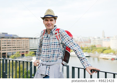 Man in straw hat standing on a terrace against Man in straw hat standing on a terrace against 49821428