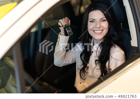 Happy customer woman buying a new car in dealeship center Happy customer woman buying a new car in dealeship center 49821763