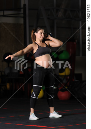 Pregnant female athlete doing hang kettlebell clean and press Pregnant female athlete doing hang kettlebell clean and press 49821783
