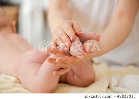 Mother massage gently baby toes, close up 49822013