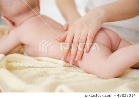 Close-up of hand on baby skin butt. Close-up of hand on baby skin butt. 49822014