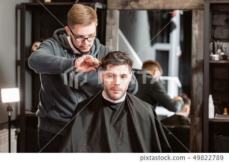 Barber work with clipper machine in barbershop. Professional trimmer tool cuts beard and hair on 49822789
