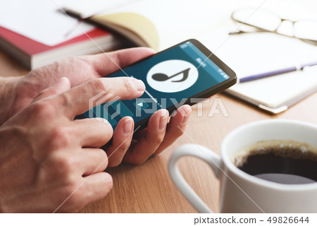 聽到在智能手機的音樂的男性手特寫鏡頭。 聽到在智能手機的音樂的男性手特寫鏡頭。 49826644