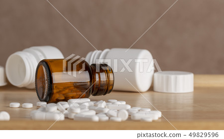 Different pill bottle and white pills Different pill bottle and white pills 49829596